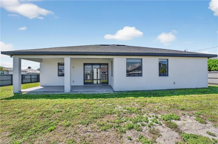 Back of house featuring a fenced backyard, a shingled roof, stucco siding, and a patio area