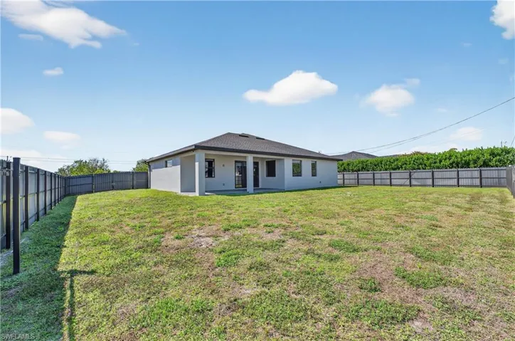 Rear view of property featuring a patio, stucco siding, and a fenced backyard