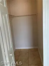 Interior closet featuring tiled flooring, a single wire shelf, and an integrated hanging rod