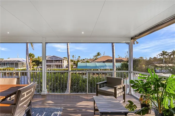 Expansive screened lanai featuring wood-finish flooring, recessed lighting, and a durable railing system