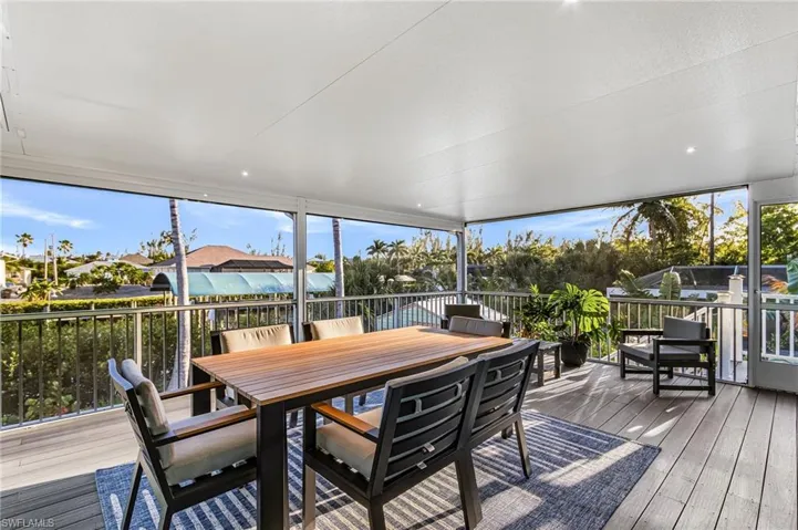 Expansive covered balcony featuring recessed lighting, a ceiling fan, and composite decking