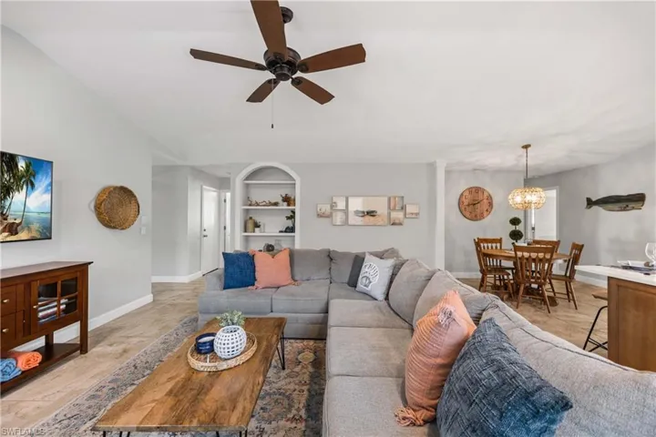 Living area features custom trim, built in shelves, and vaulted ceilings.  Neutral toned tile floors throughout.