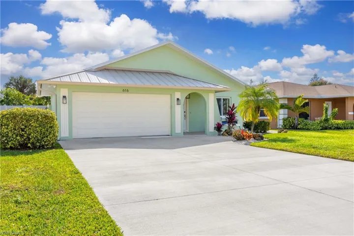 Clean, warm and inviting exterior featuring double garage, long driveway and the preferred roof in Naples: Metal.