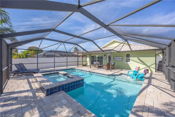 View of the spacious swimming pool, spa and screened lanai area.