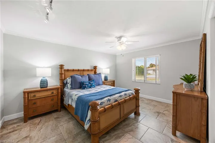 Guest bedroom 1 is tastefully trimmed with crown molding and mellow tones.