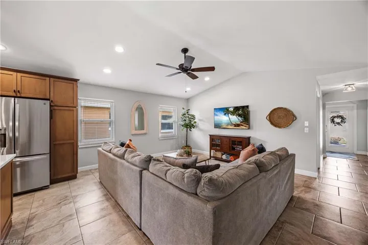 Living area features custom trim, built in shelves, and vaulted ceilings.  Neutral toned tile floors throughout.