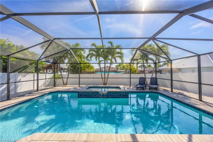 View of swimming pool and spa with a calming water feature spill.  The fenced back yard provides lots of privacy.