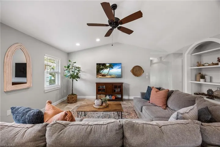 Living area features custom trim, built in shelves, and vaulted ceilings.  Neutral toned tile floors throughout.
