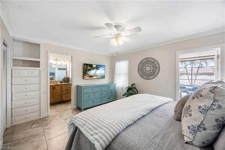 Master bedroom with crown molding, custom built in cabinets and ensuite bath.  Easy-quick door access to your sparkling pool too!
