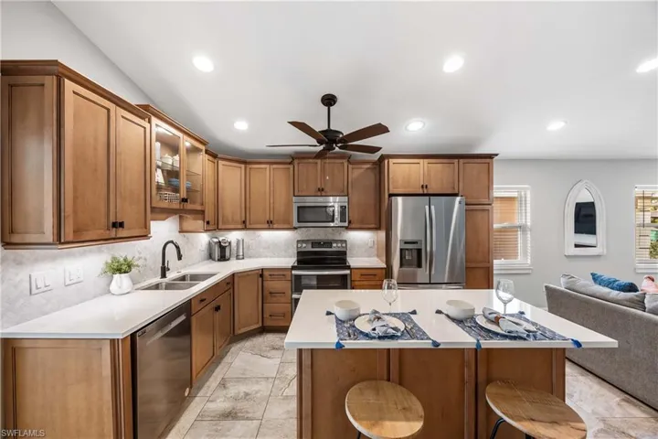 Updated kitchen boasts sparkling backsplash and countertops along with  stainless steel appliances.  Kitchen opens to the living room and dining area.