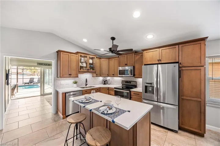 Kitchen featuring abundant natural light, stainless steel appliances and vaulted ceiling.