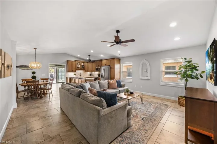 Living area features custom trim, built in shelves, and vaulted ceilings.  Neutral toned tile floors throughout.