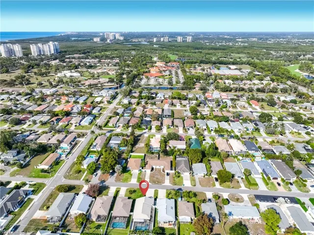 Aerial view of property and surrounding area featuring nearby suburban area and a large body of water