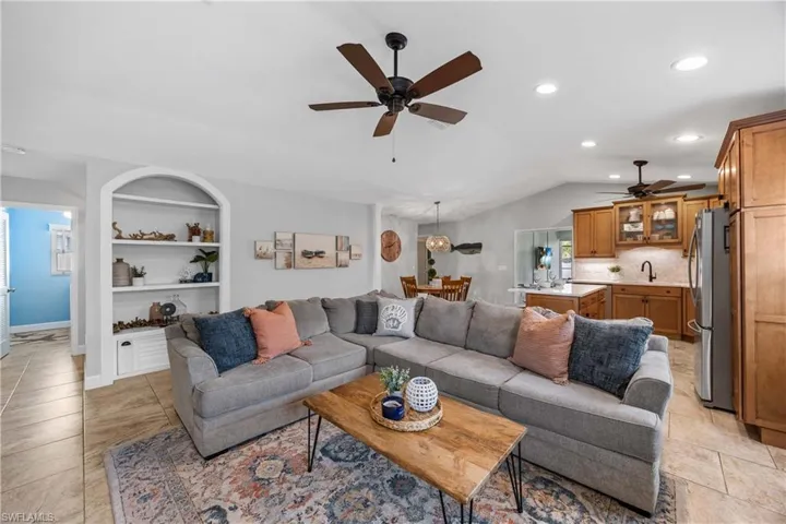 Living area opens to kitchen with custom built in shelves, recessed lighting and  lofted ceiling.