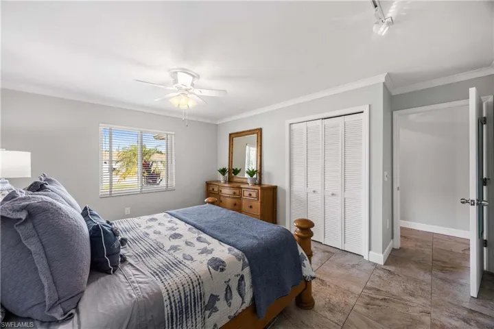 Guest bedroom 1 is tastefully trimmed with crown molding and mellow tones.