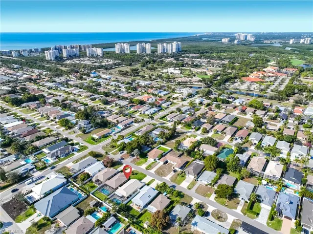 Aerial view of property and surrounding area featuring nearby suburban area