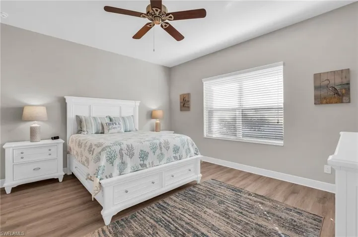 Bedroom with ceiling fan and dark hardwood / wood-style floors