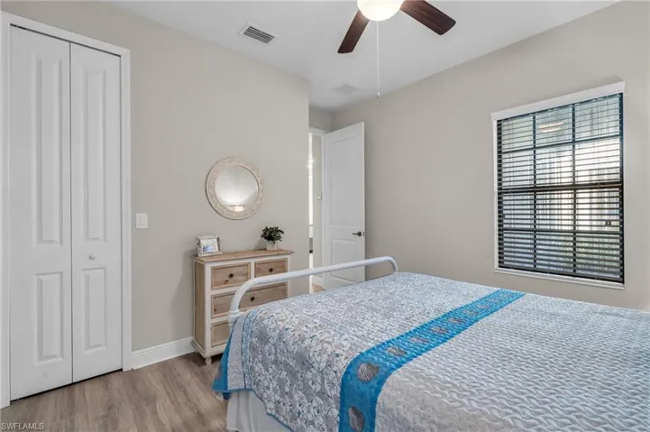 Bedroom with a closet, light wood-type flooring, and ceiling fan