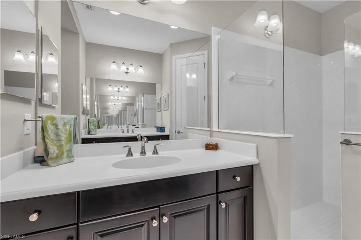 Bathroom featuring a tile shower and vanity
