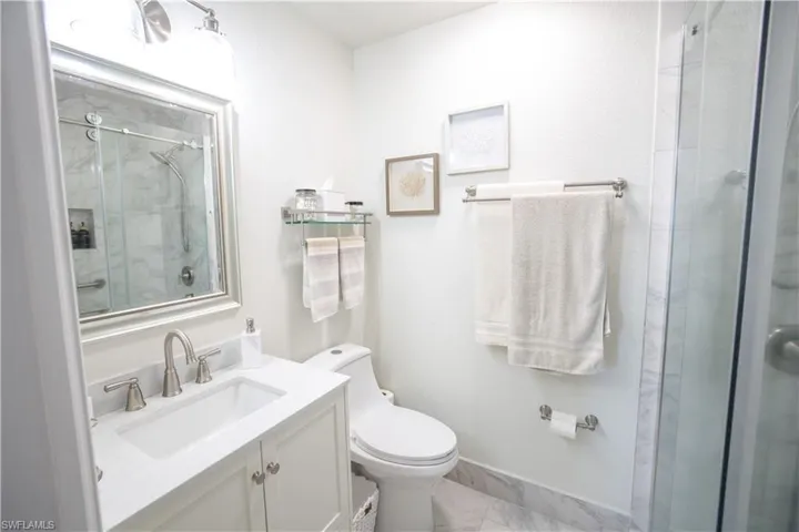 Full Master bath featuring a shower stall, vanity, and marble finish floors