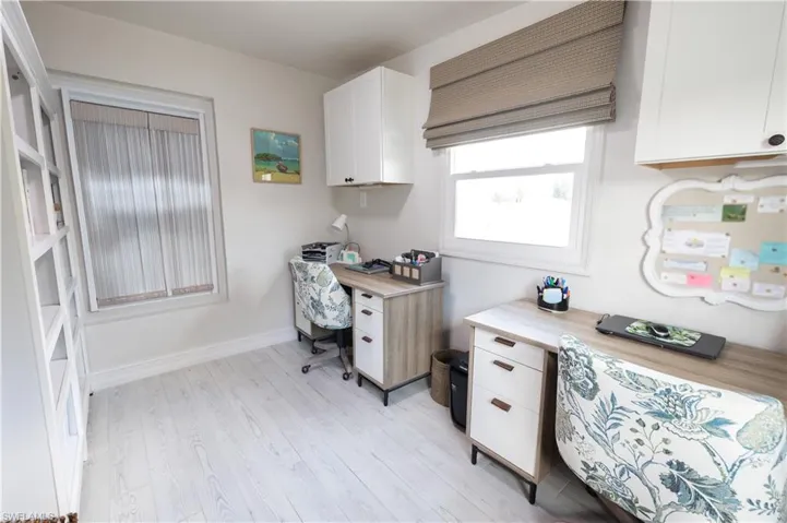 Office area with light wood-style flooring and baseboards