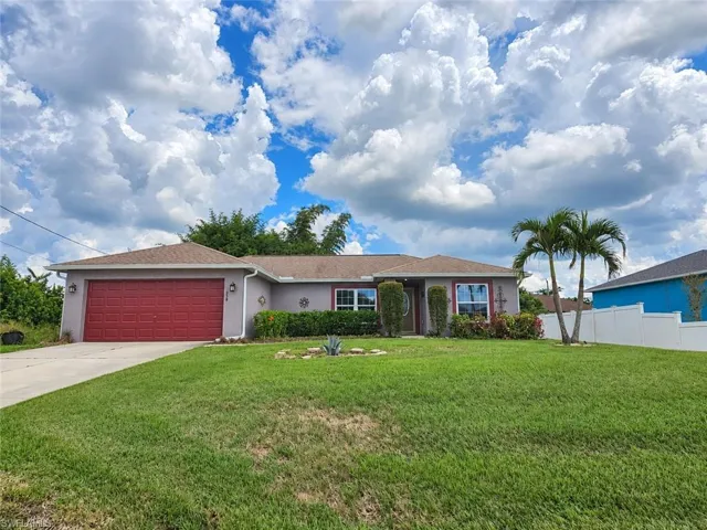 Concrete driveway leading to a two-car garage with a red door