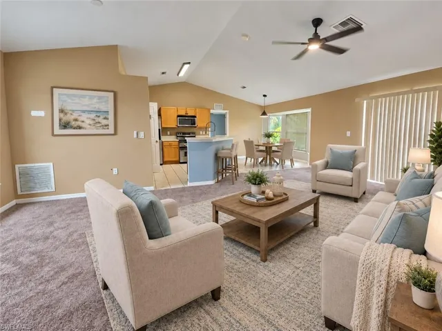 Vaulted ceilings, a ceiling fan, and a neutral color palette