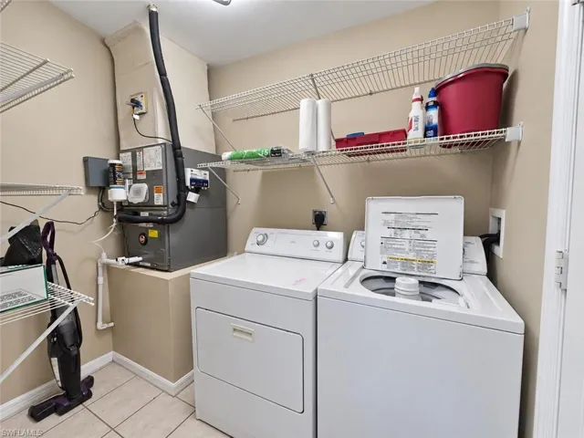Utility space featuring tiled flooring and integrated shelving