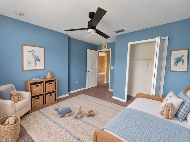 Room featuring a ceiling fan, carpet flooring, and a bi-fold closet door