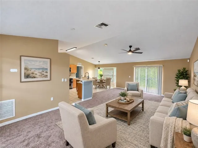 Vaulted ceiling with a ceiling fan, recessed lighting, and sliding glass doors