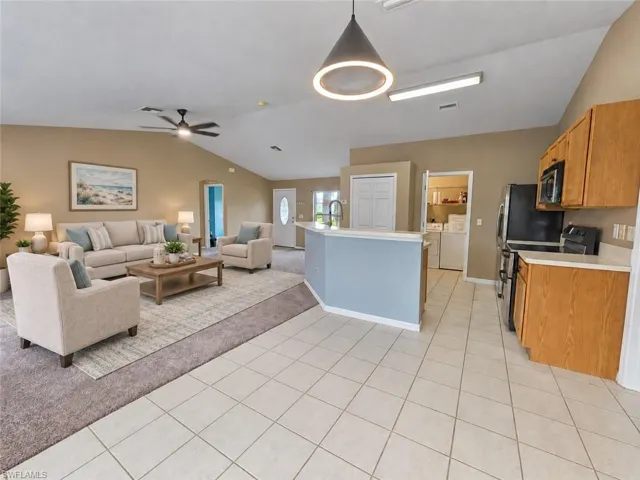 Vaulted ceilings with a ceiling fan, recessed lighting, and a pendant light fixture