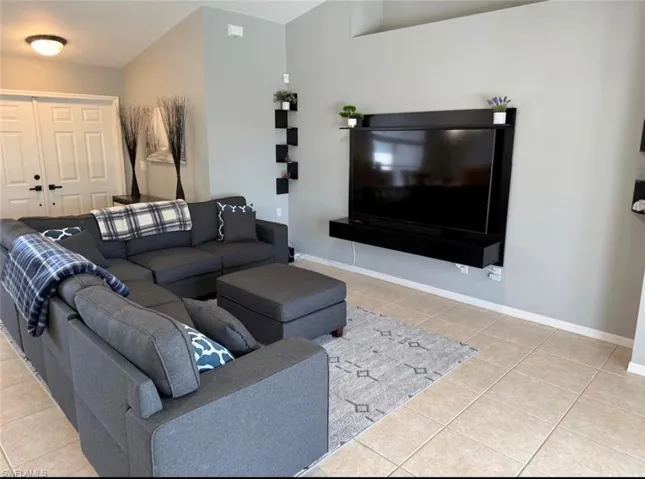 Living room featuring light tile patterned floors and baseboards