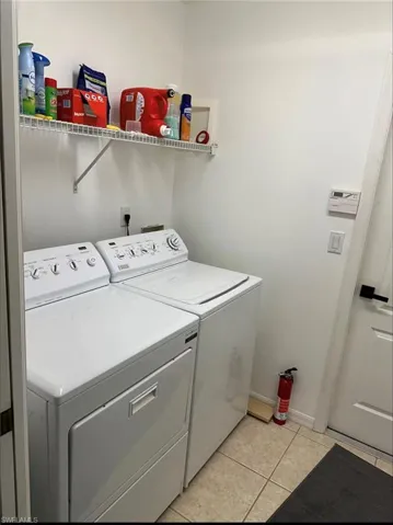 Laundry room featuring light tile patterned flooring and washer and dryer