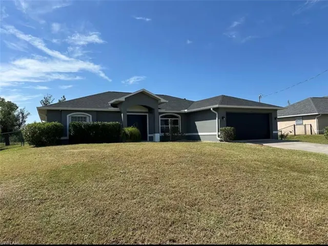 Single story home with stucco siding, driveway, and a garage