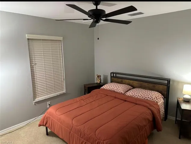 Bedroom with ceiling fan and carpet flooring