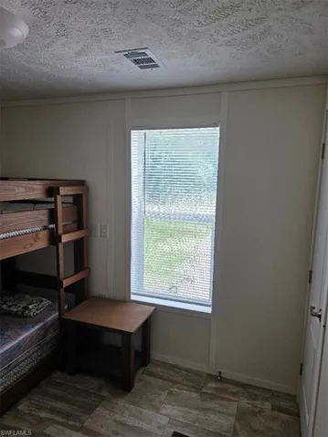 Bedroom with a textured ceiling and ornamental molding
