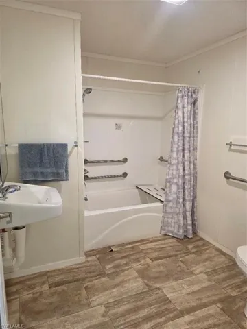 Full bath featuring shower / tub combo and ornamental molding