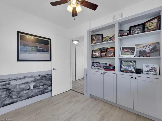 Bedroom with vinyl wood-style flooring, ceiling fan, handcrafted, built in bookcase