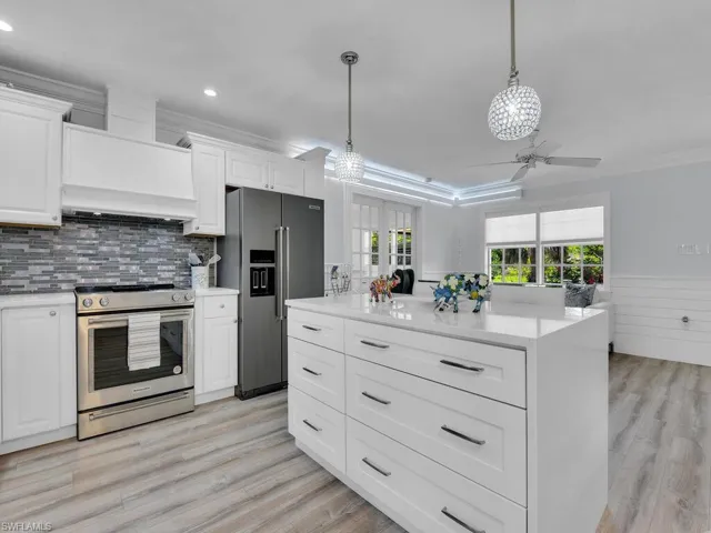 Kitchen with stainless steel KitchenAid appliances and a wealth of cabinetry for storage and natural light throughout