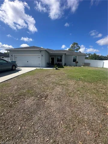 Ranch-style home with stucco siding, an attached garage, and driveway