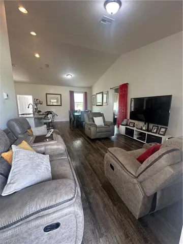 Living room with wood-type flooring and lofted ceiling