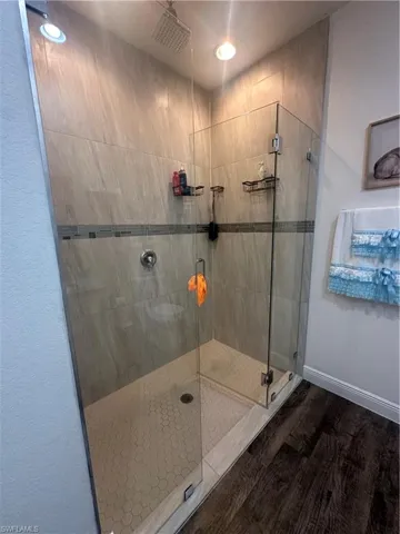 Bathroom with a shower stall, wood finished floors, and recessed lighting