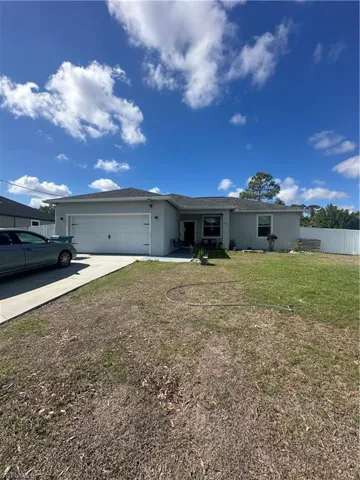 Ranch-style house featuring stucco siding, a garage, and concrete driveway