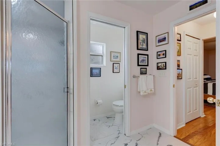 Bathroom with a shower stall and light marble finish floors