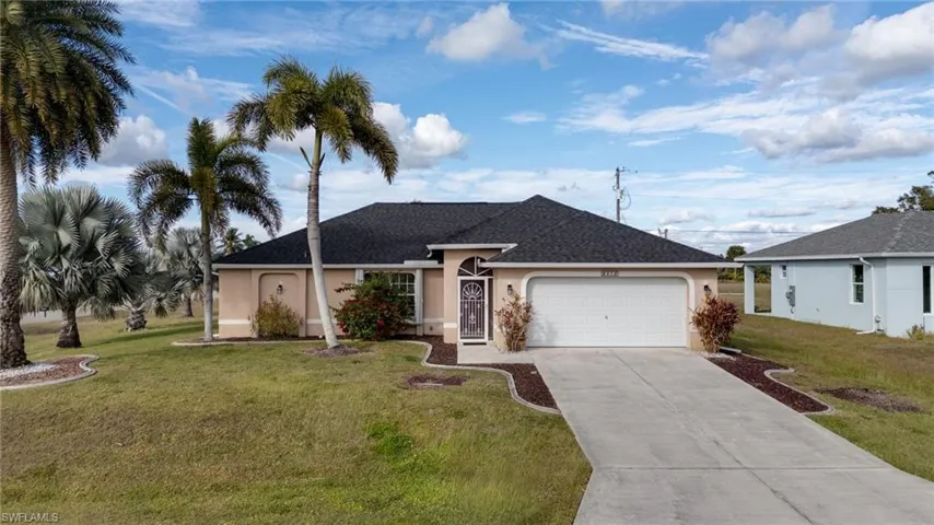 Single story home featuring a front yard, stucco siding, driveway, and an attached garage