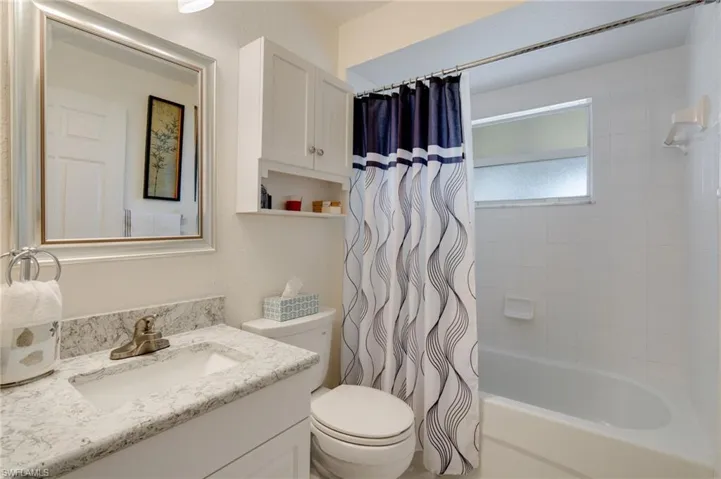 Bathroom with shower / bath combo with shower curtain and vanity
