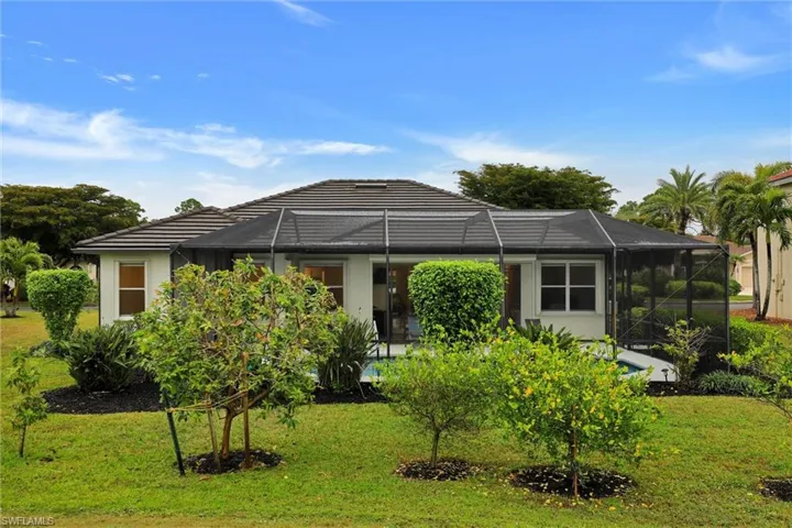 View of front of property featuring a lanai, a sunroom, a front yard, and stucco siding