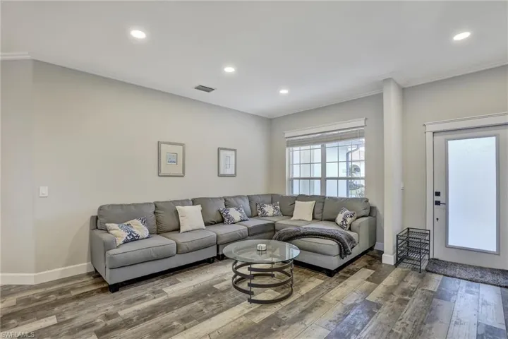 Living area featuring hardwood / wood-style flooring, recessed lighting, and crown molding