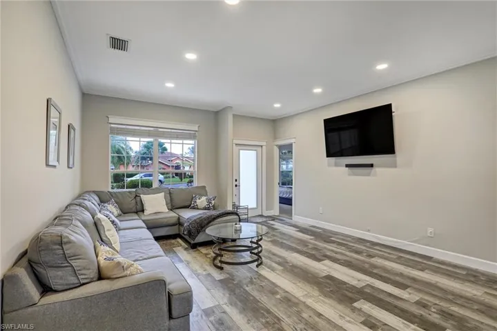 Living area featuring recessed lighting, hardwood / wood-style floors, and ornamental molding