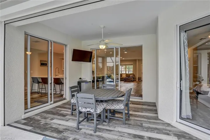 Dining space featuring a textured wall, wood finished floors, and a ceiling fan